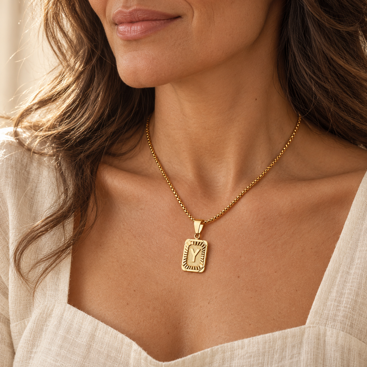 Textured gold rectangular Y initial necklace on model