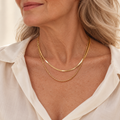 Layered gold chain necklace stack on model