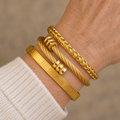 Three gold bracelet stack on mature wrist