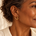 Evelise gold heart hoop earrings on a woman