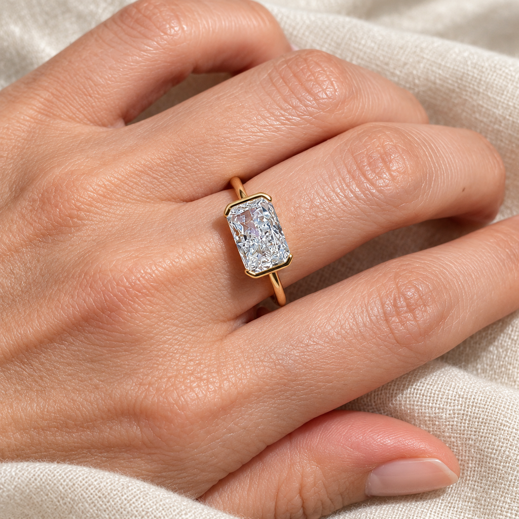 Evelise east west emerald cut ring on a hand