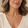 Gold cursive K initial necklace on a woman