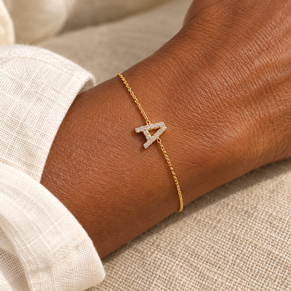 Gold A initial chain bracelet on a woman's wrist