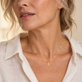 Fine gold serif A initial necklace on mature model