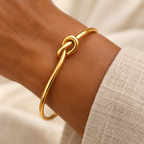 Gold knot bangle on a woman's wrist