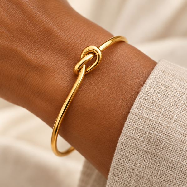 Gold knot bangle on a woman's wrist