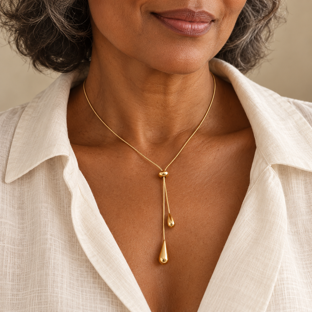Gold pull lariat necklace with two droplet ends on a woman